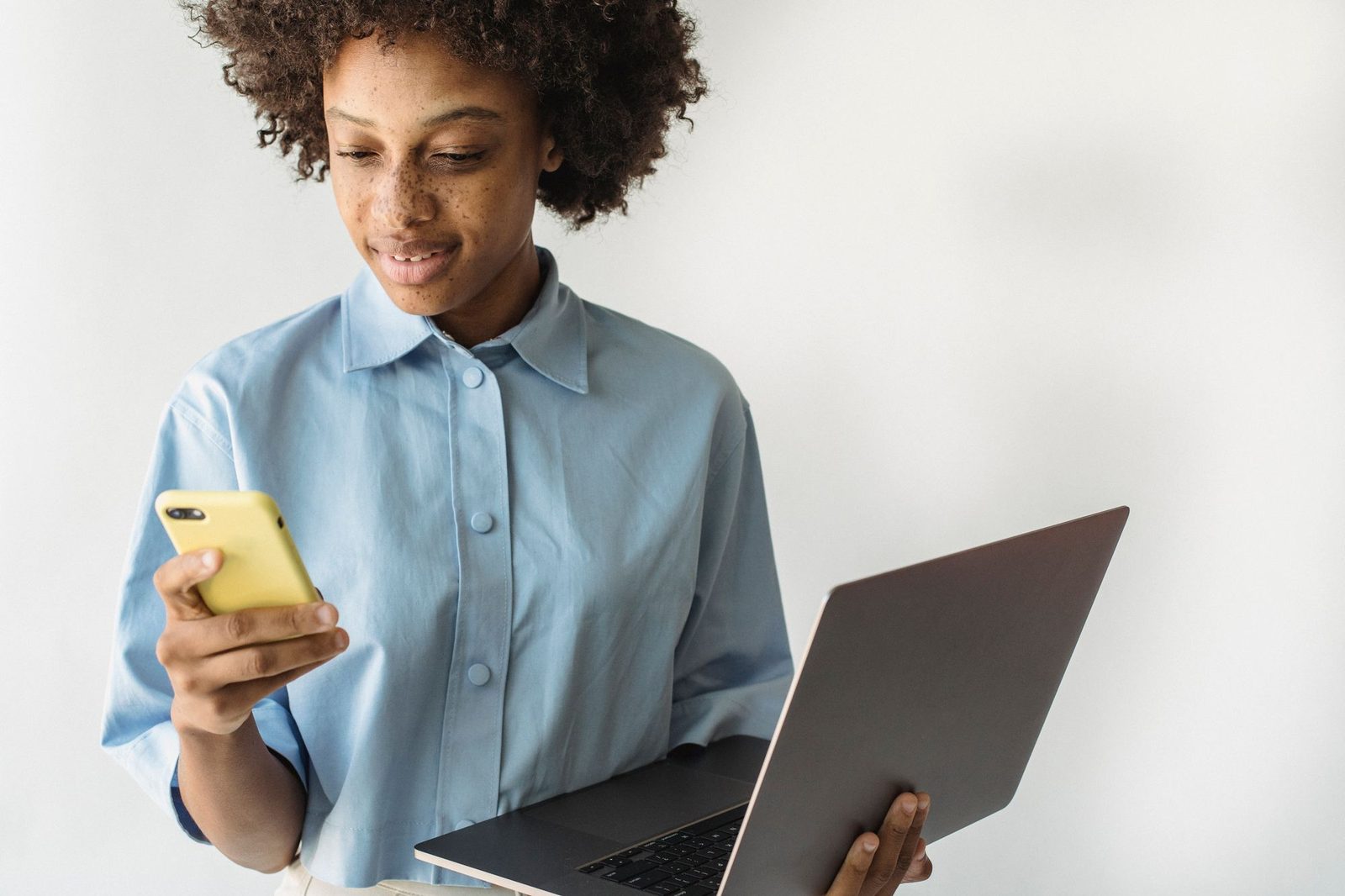 Woman checking a website on her phone and laptop